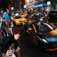 April 16, 2015 - New York, NY : A group of boys gawk at, and take selfies with, a high-end sports car as it passes through Duffy Square in Times Square on Thursday evening, April 16. CREDIT: Karsten Moran for The New York Times